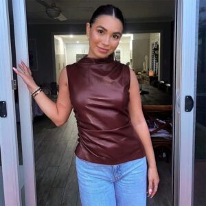 Woman posing in a doorway, wearing a PU Leather Tank Top and blue jeans.
