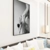 A black and white framed artwork of a dancer in motion, displaying Grace, displayed on a living room wall above a sofa with decorative pillows.