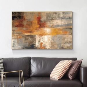 Abstract painting with warm and neutral tones displayed above a black leather sofa with decorative pillows, radiating VIBRANCE.