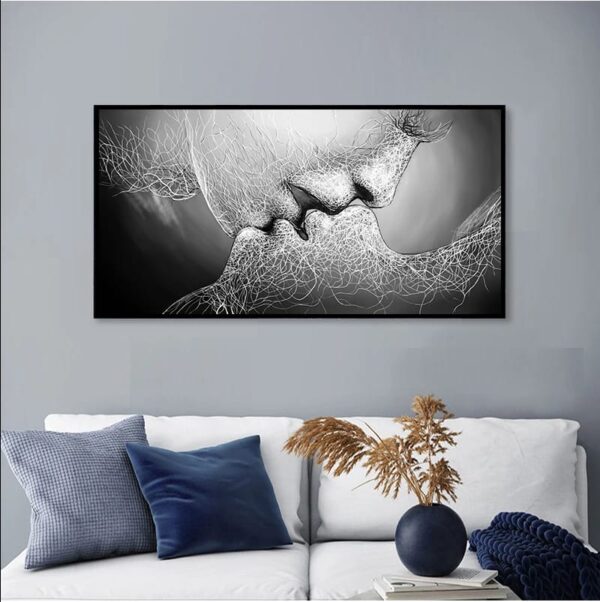 Abstract monochrome artwork depicting a LOVE KISS, displayed above a couch with decorative pillows and a plant to the side.