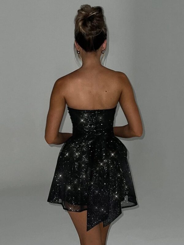 Woman in a sequin bow corset dress standing with her back to the camera.