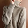 Sentence with the product name included: A person in a textured beige Loose Cashmere Sweater, viewed from behind, with the collar pulled up over the lower half of their face.