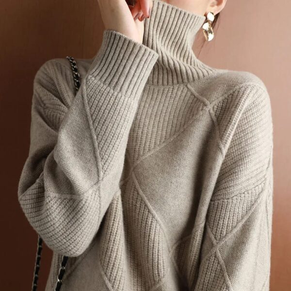 Sentence with the product name included: A person in a textured beige Loose Cashmere Sweater, viewed from behind, with the collar pulled up over the lower half of their face.