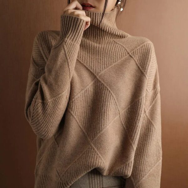 A person in a textured LOOSE CASHMERE SWEATER with a diamond pattern, partially covering their face.