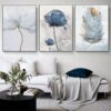 A serene living room featuring a white sofa with a throw blanket and blue pillows, complemented by a triptych of SCANDINAVIAN FLOWER wall art.