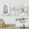 Sentence with product name: A triptych of serene SCANDINAVIAN FLOWER wall art above a modern white sofa, with a charming wooden toy on the floor.