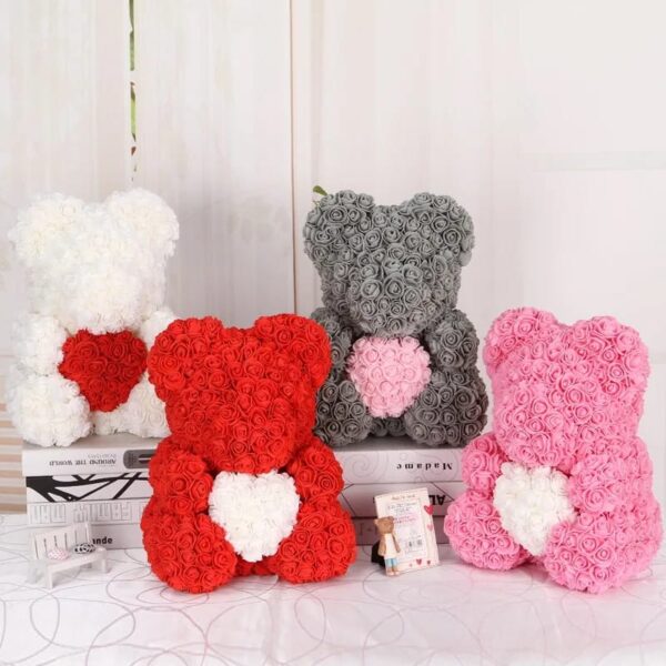 Displayed are four Teddy Bears of Roses, crafted from artificial blooms in white, gray, red, and pink. Each bear has a heart of a contrasting color on its chest.